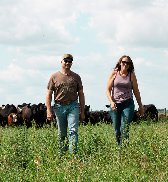 Two ranchers in a field with their cattle